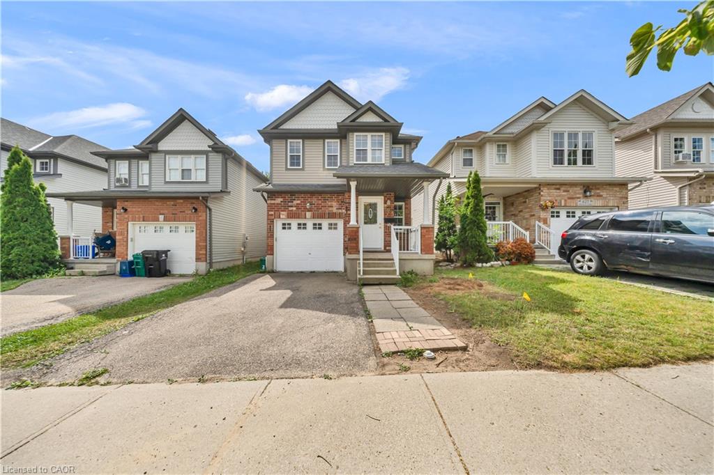 Two-story residence featuring a brick and siding exterior, an integrated single-car garage, and a paved driveway