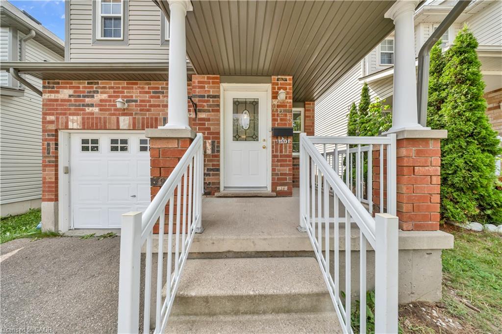 Brick and siding exterior featuring a white garage door with upper window inserts