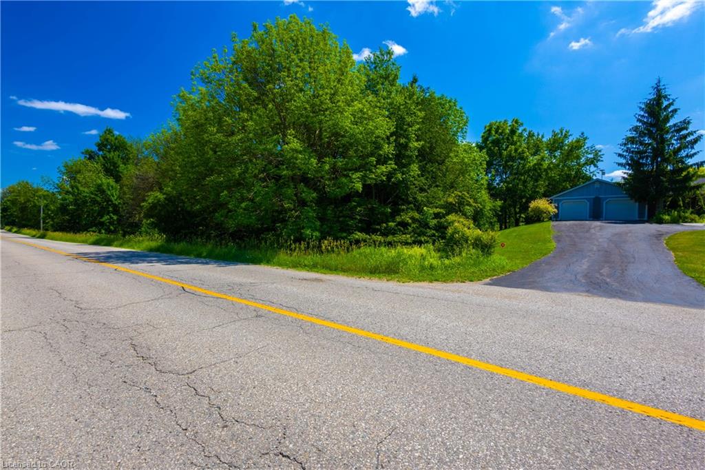 Paved driveway leading to a detached two-car garage with blue siding