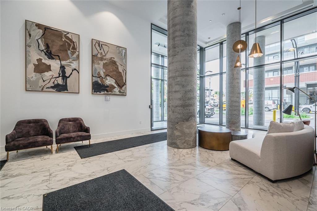Spacious lobby featuring polished stone tile flooring, floor-to-ceiling windows, and concrete support columns