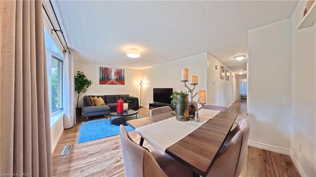 Wood-finish flooring throughout, bay window with curtain rods, and recessed wall shelving