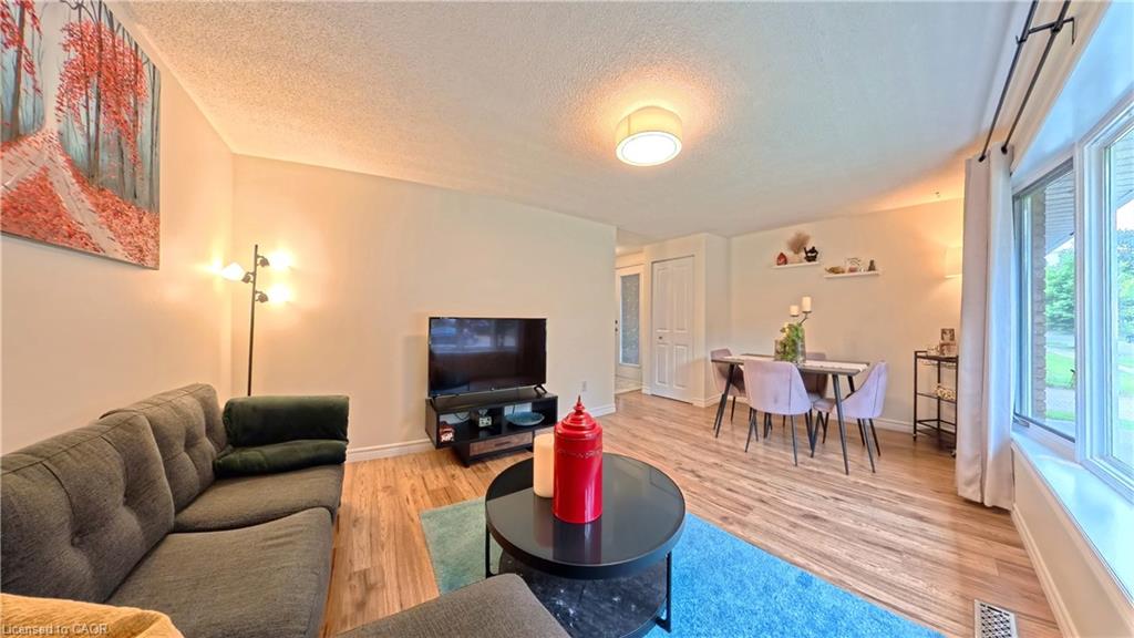 Wood-finish flooring throughout, bay window with multiple panes, recessed ceiling light fixture, and a built-in closet with bifold doors