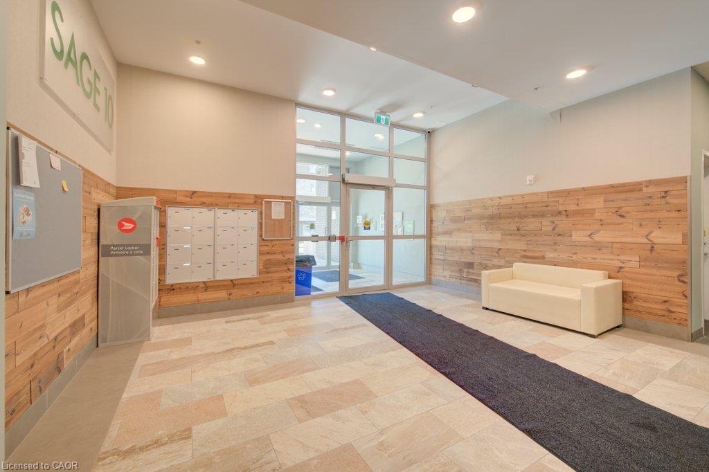 Building lobby featuring light-toned rectangular floor tiles, wood-paneled walls, mailboxes, and a glass-paneled entrance door
