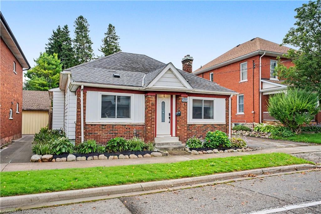 Brick exterior with white trim, a gabled roofline, and a paved driveway