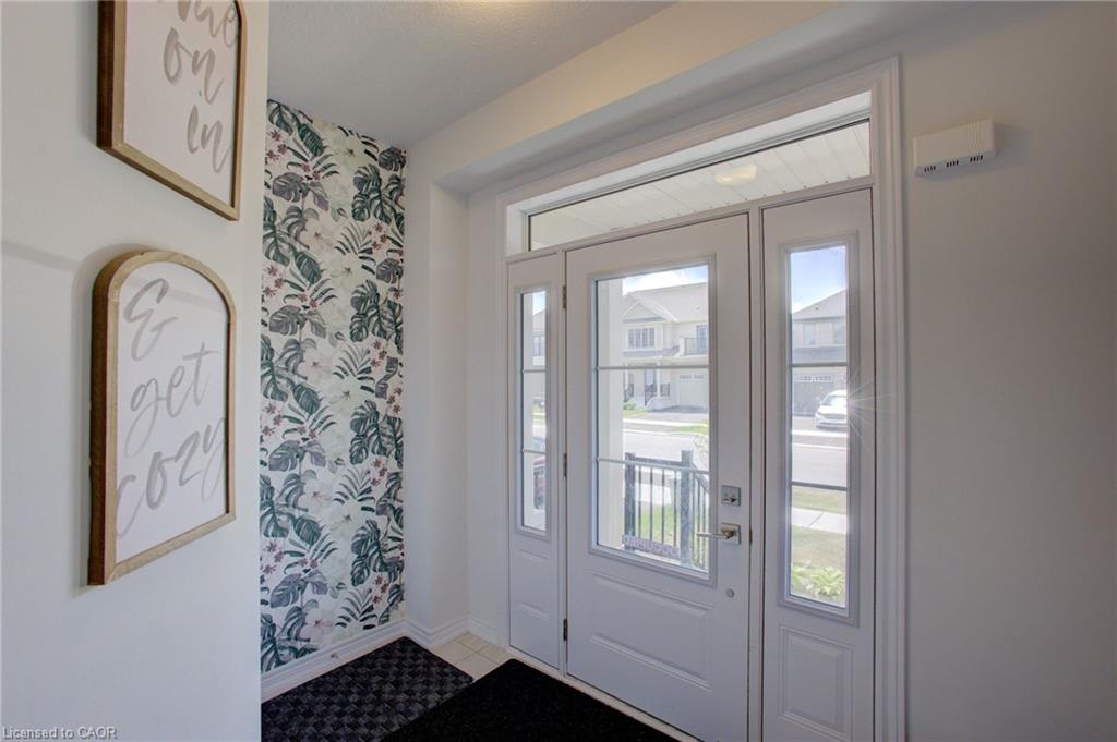 Entryway featuring a white door with multiple glass panes, a coordinating sidelight, and an overhead transom window
