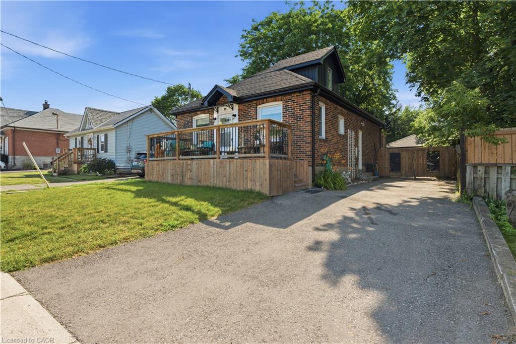Brick home with a large wooden deck featuring black railings