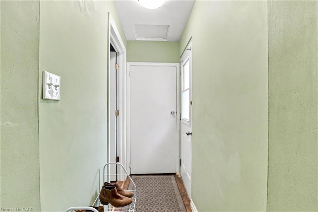 Hallway featuring light green wall paint and a patterned floor runner
