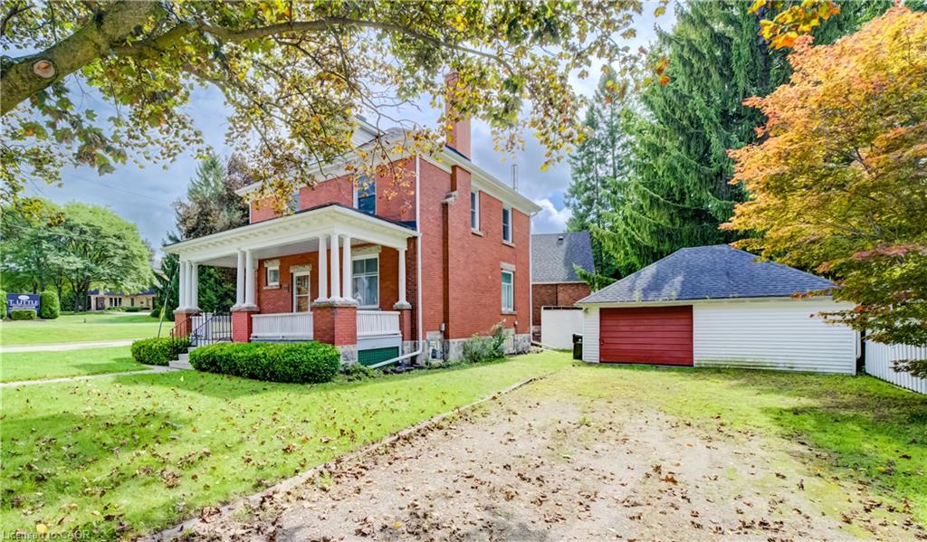 Brick exterior with white trim, covered front porch with pillars, detached garage