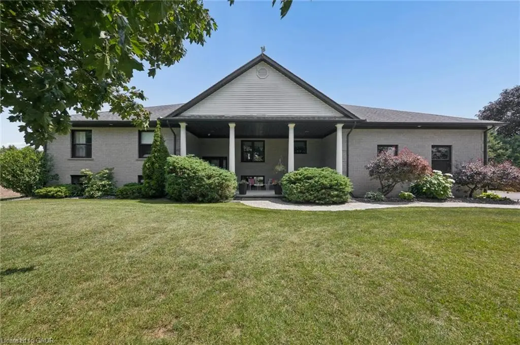 Expansive front lawn leading to a covered porch with white columns