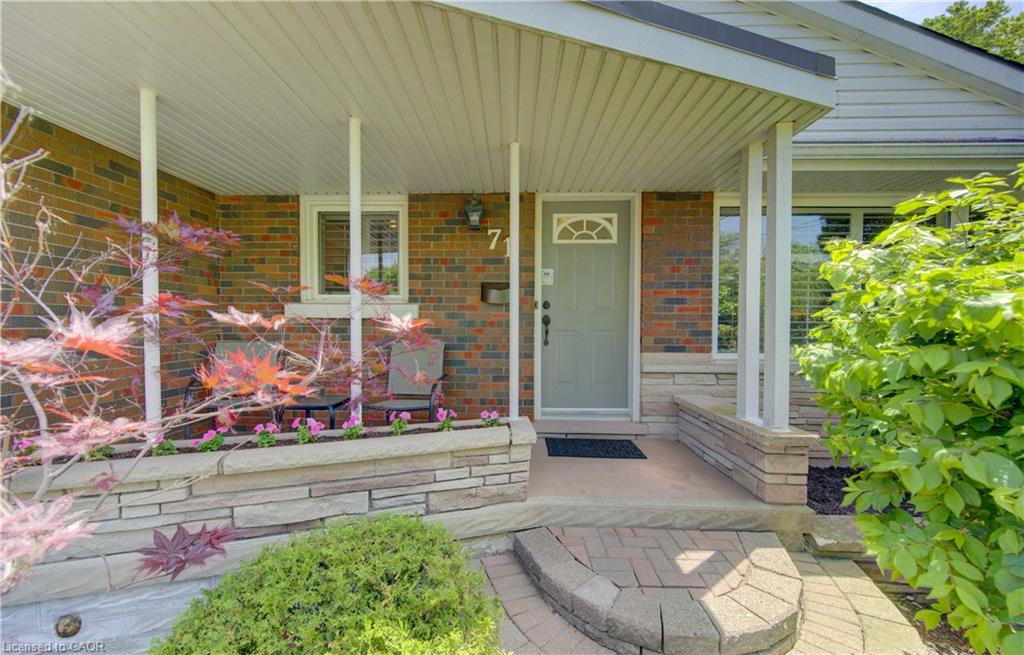 Brick exterior with a covered porch featuring white support columns and a light gray entry door
