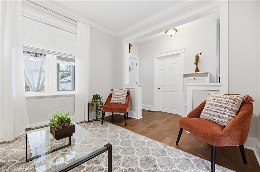 Wood-finish flooring, white trim, and crown molding accent the interior space