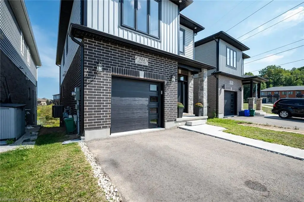 Contemporary exterior featuring a combination of brick and vertical siding, a paved driveway, and an attached single-car garage with modern glazing accents