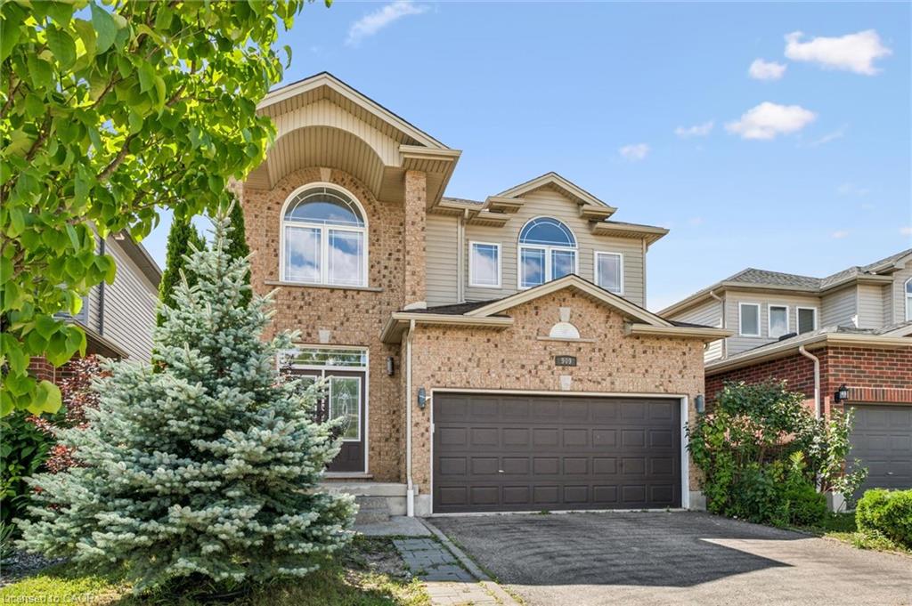Brick and siding exterior with arched windows, an attached two-car garage, and a paved driveway