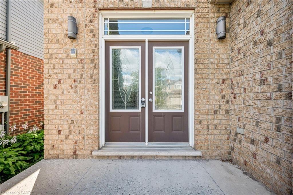 Brick exterior facade featuring a double entry door with decorative glass inserts and an overhead transom window
