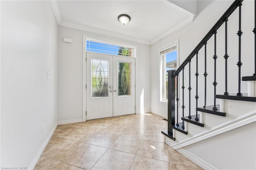 Double front entry doors with decorative glass inserts, transom window, and sidelights