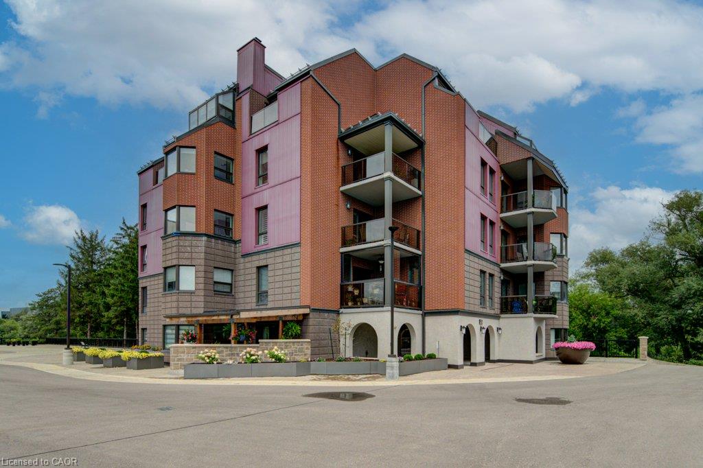 1- Multi-level structure with a brick exterior, multiple balconies with glass railings, arched entryway, and integrated planters