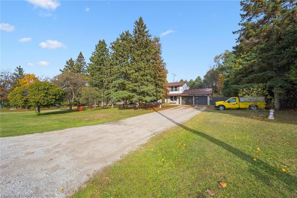 View of front of property featuring driveway, a front yard, and a garage