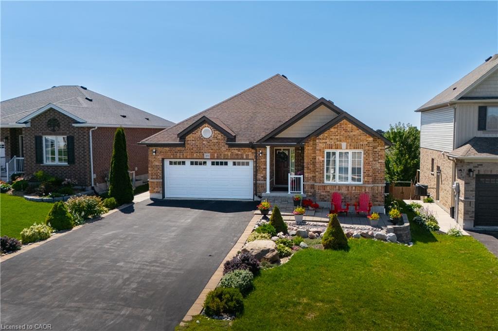 Brick facade, attached garage, gabled roofline, concrete front porch, and paved driveway