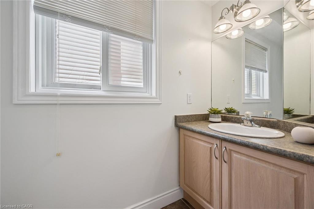 Bathroom featuring a vanity with a light wood-finish cabinet, integrated sink, and laminate countertop