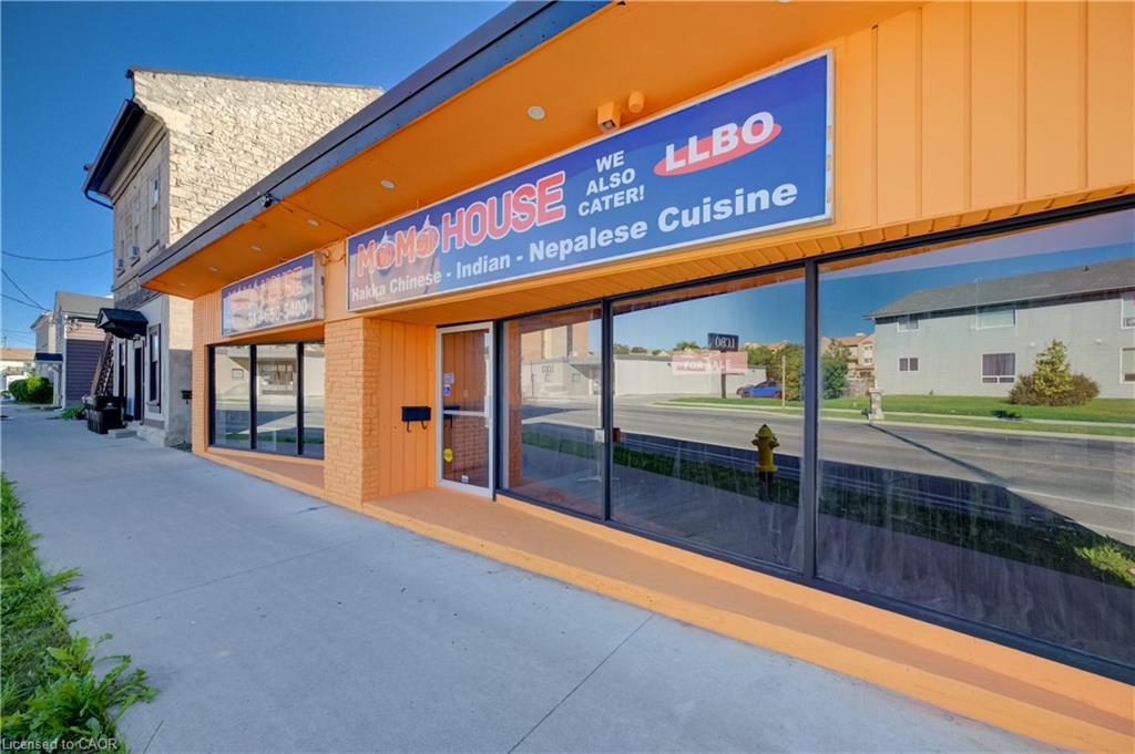 Exterior commercial facade featuring large display windows, a prominent entrance, and a wide sidewalk