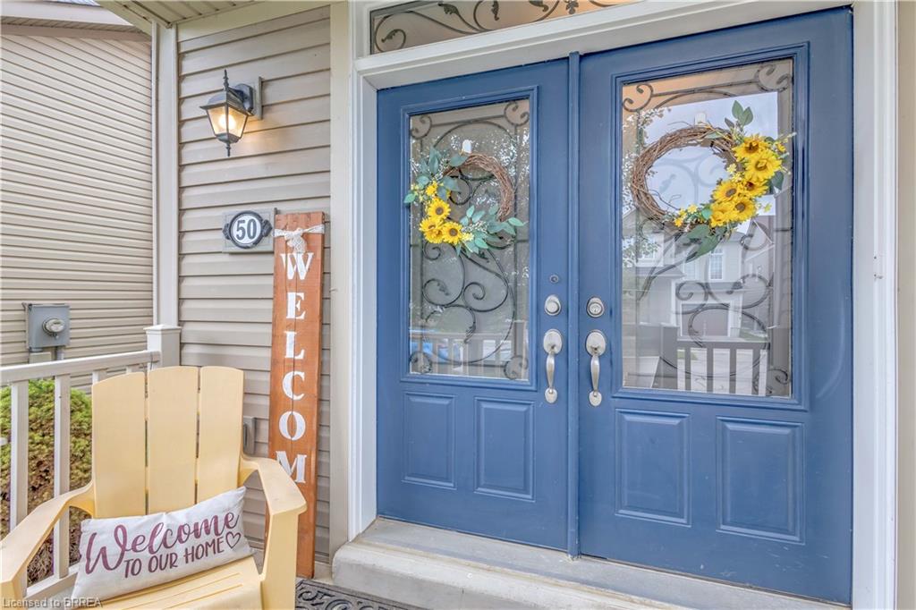 Blue double entry doors with decorative glass inserts and brushed nickel hardware