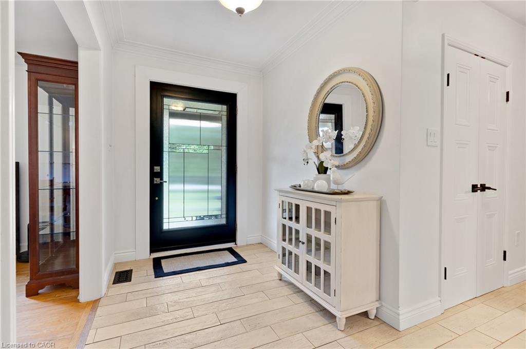 Entryway featuring a decorative transom door, light-toned tile flooring, and crisp white walls