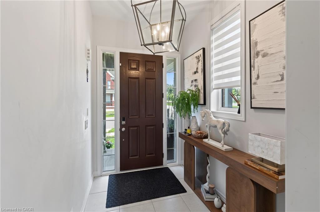 Entryway featuring a dark wood panel door, sidelight windows, and a geometric-style pendant light fixture