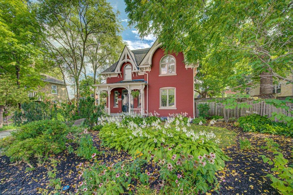 Red brick exterior with white trim, arched windows, and a covered front porch featuring decorative columns