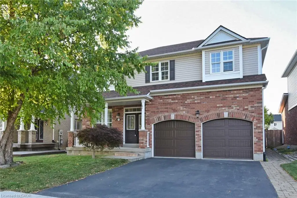 Two-story exterior featuring a brick and horizontal siding facade, covered front porch with columns, and a two-car attached garage with arched entryways