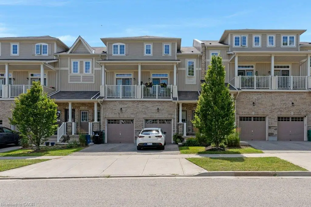 Townhome exterior featuring brick and siding construction, covered entry, second-story balconies with white railings