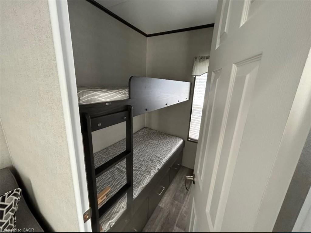 Unfurnished bedroom with dark wood-type flooring and crown molding
