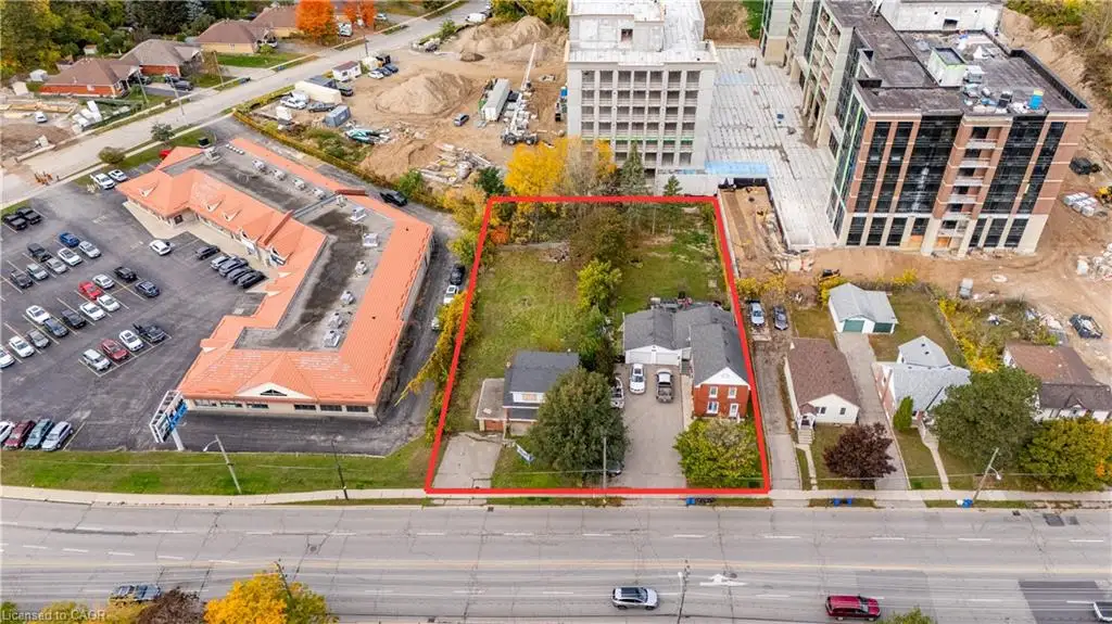 Aerial perspective of a rectangular parcel featuring two residential structures, a shared driveway, and mature landscaping
