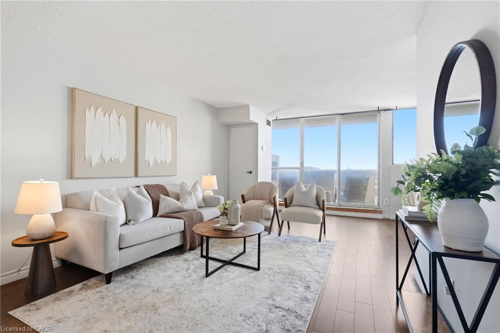 Expansive windows, wood-finish flooring, and white walls create a bright living space