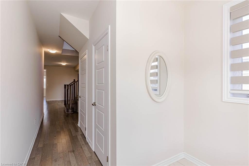Hallway featuring wood-finish flooring, recessed lighting, and white paneled doors