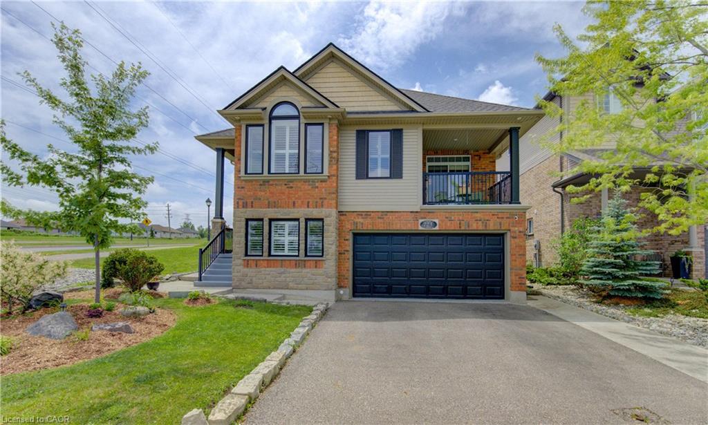 Brick and siding exterior featuring an attached garage with a dark panel door
