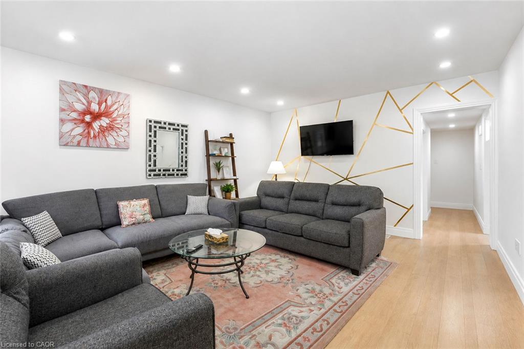 Recessed lighting illuminates the living space featuring light wood-finish flooring