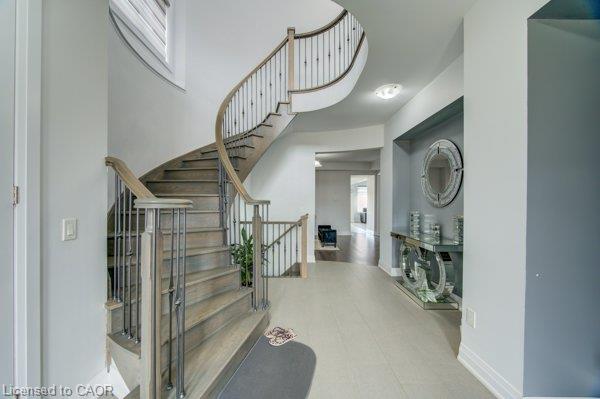 Curved staircase with wood-finish treads and wrought iron spindles