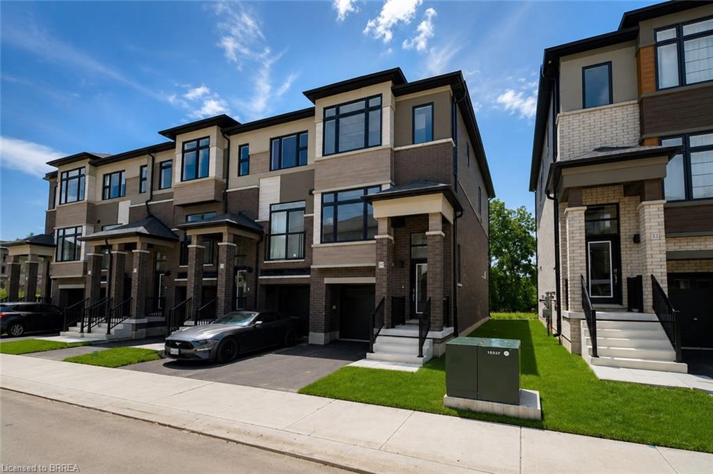 Contemporary townhouse exterior featuring a multi-tone facade, prominent windows, and integrated garage access