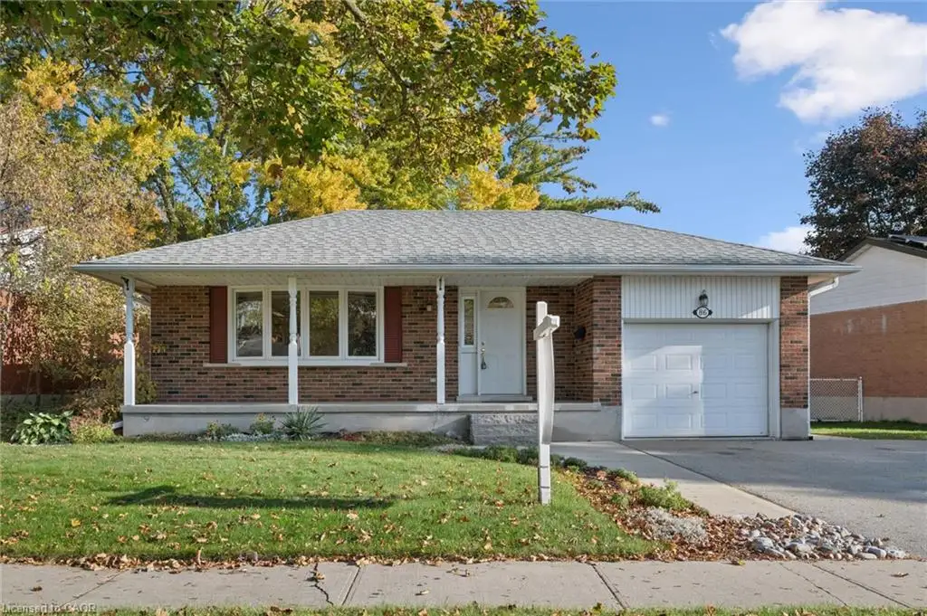 Single-story brick exterior featuring a covered front porch, asphalt shingle roof, attached garage, and paved driveway