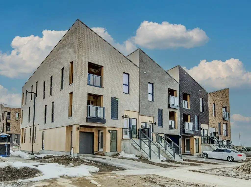 Contemporary architectural design featuring a light-toned brick facade, vertical window accents, and multiple private balconies with glass railings