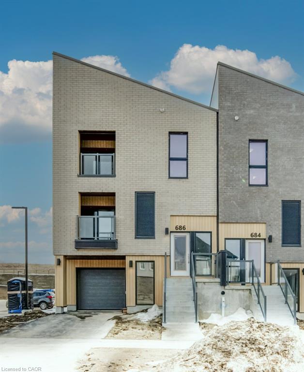 Modern exterior featuring light-colored brick, contrasting wood-finish siding, and a prominent peaked roofline