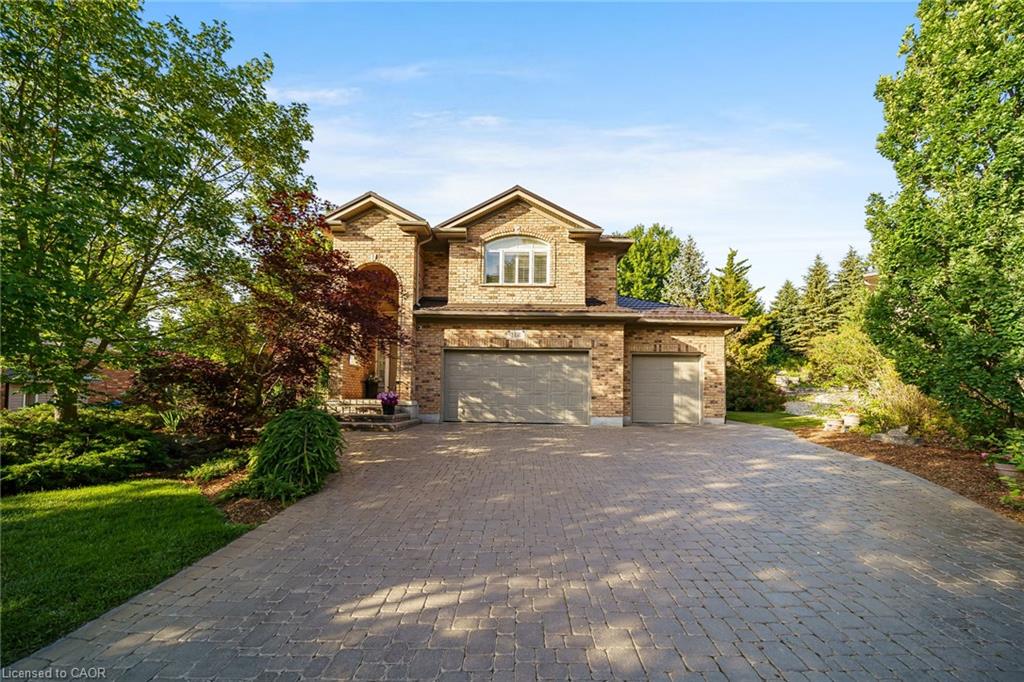 Brick facade residence with a two-car garage and an additional single-car garage
