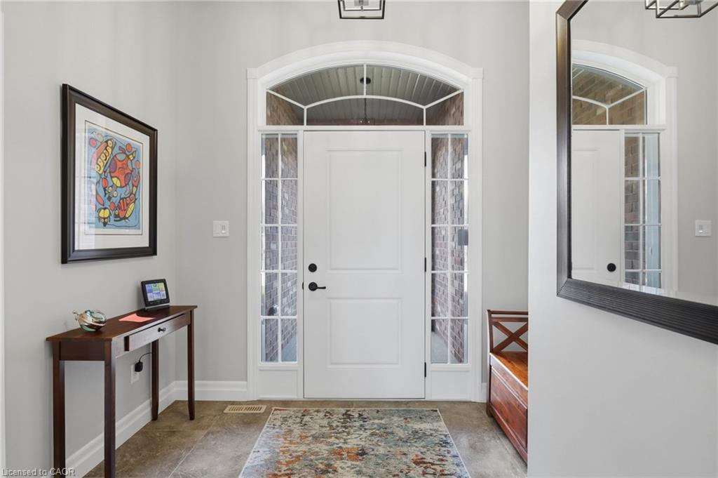 White paneled entry door with sidelights, transom window, and black hardware