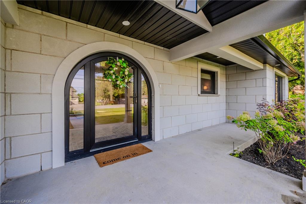 Arched double entry doors in a black finish, set within a light-toned block exterior