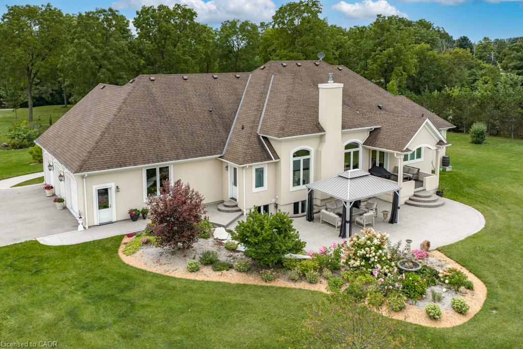 Expansive exterior with a stucco finish, multi-level patio, and a covered outdoor living area