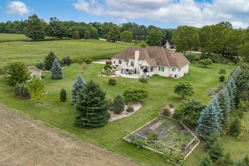 Expansive green lawn with mature trees and a dedicated garden area