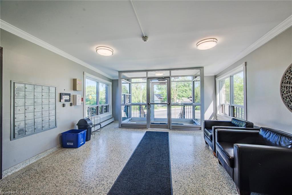 Building entrance featuring a glass-enclosed vestibule, terrazzo flooring, and multiple windows