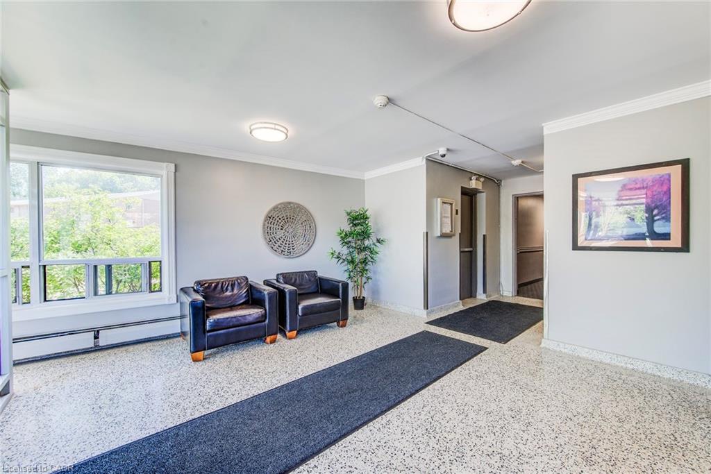 Lobby featuring terrazzo flooring, crown molding, a large window, recessed lighting, and elevator access