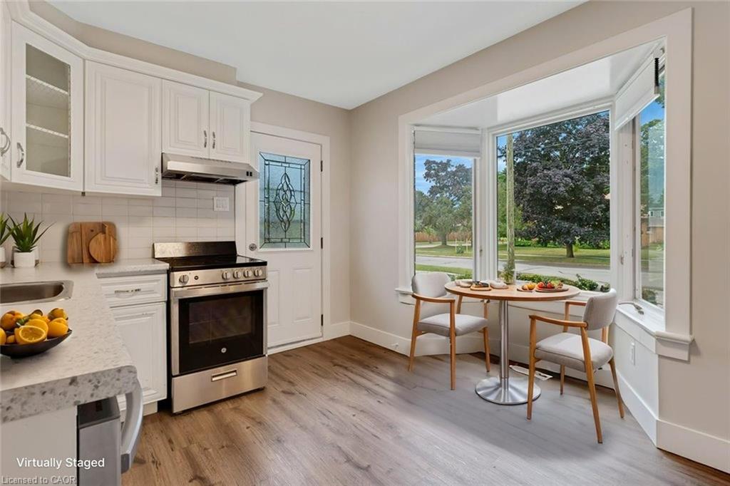 Kitchen featuring white cabinetry, stainless steel range, and a subway tile backsplash