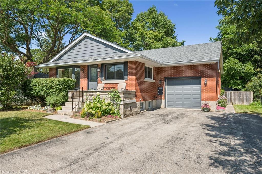 Brick exterior with grey siding accents, attached single-car garage, front porch with stone features, and a paved driveway